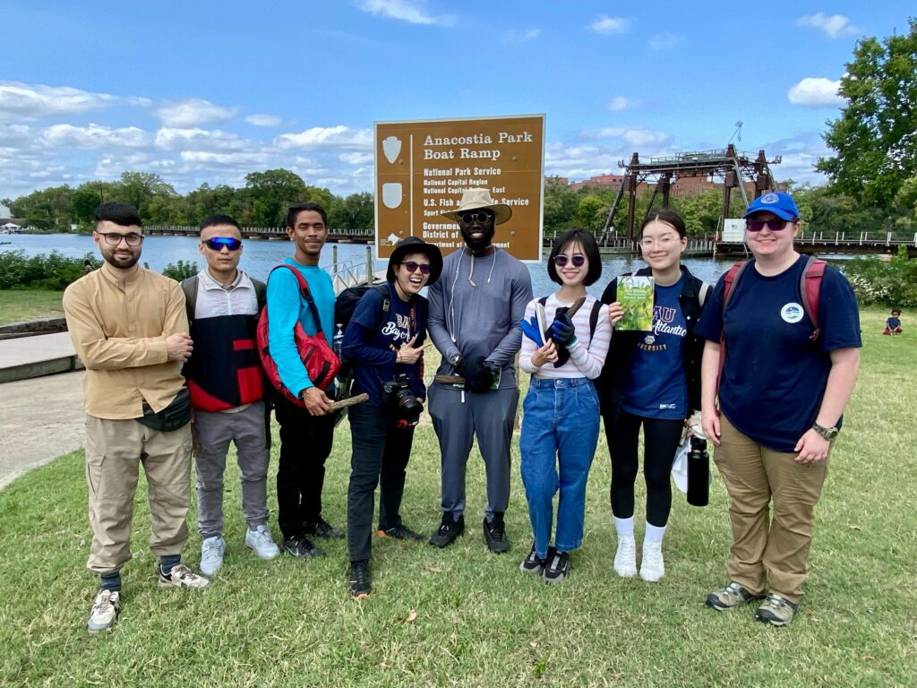 IMG_2866 Group of people at Anacostia Park Boat Ramp, smiling and posing for a photo on a sunny day.
