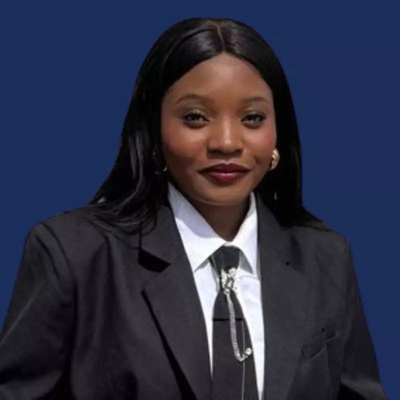 Businesswoman in a black suit and white shirt on a blue background, exuding confidence and professionalism.