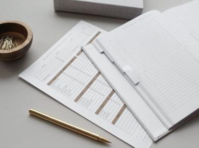 How to Become a Financial Manager: A Career Guide 18 Budget planner and finance tracker on a desk with a gold pen and bowl of paper clips.