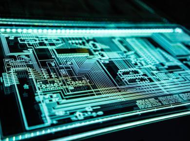 Top Cyber Security Skills to Combat Cyber Threats 13 Close-up of a glowing electronic circuit board with intricate patterns and lines, representing modern technology.