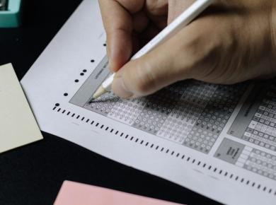 The Ultimate Guide to Standardized Tests in the United States 17 Filling out a multiple-choice answer sheet with a pencil for an exam or test assessment.