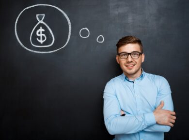 Unlocking Income Insights: Understanding ESL Teacher Salary 24 Man in blue shirt with arms crossed, standing by chalkboard, thinking about money.