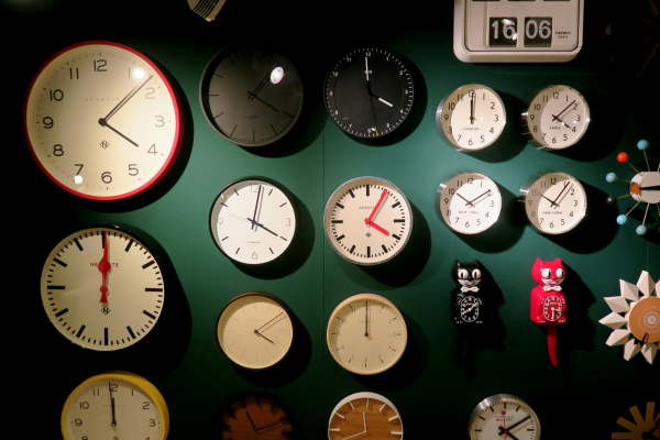 Wall display with various clocks showing different times, visually representing time management skills in the fast-paced tech industry