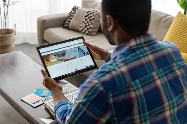 Young professional updating LinkedIn profile on tablet as part of personal branding and networking strategy.