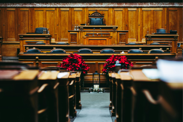 Empty government assembly hall with wooden benches and flowers, depicting legislative roles and political science careers in government.