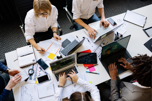Team collaborating at a shared workspace, emphasizing the role of work experience in building practical skills.
