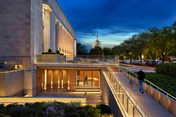 Exterior view of the Folger Shakespeare Library in Washington, D.C., at dusk, with the U.S. Capitol dome visible in the background. Photo © Alan Karchmer / OTTO, courtesy of KieranTimberlake.