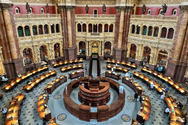 Interior view of the Main Reading Room at the Library of Congress in Washington, D.C., featuring ornate architecture, circular desks, and scholars at work. Photo by Abdullah Guc on Unsplash.