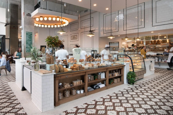 Interior of Tatte Bakery & Café in Washington, D.C., featuring a bright, stylish counter filled with fresh pastries and breads. 
