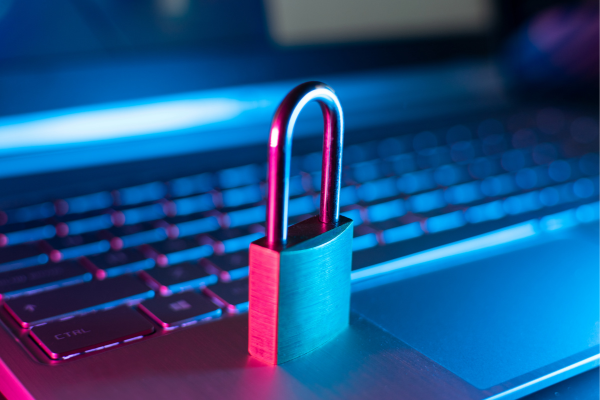 Padlock on a laptop keyboard, symbolizing cybersecurity and data protection with vibrant blue and pink lighting.