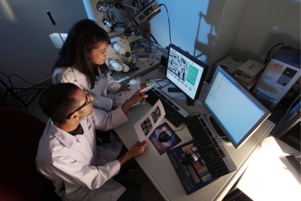 Scientists analyzing data on computers in a laboratory setting.