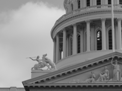 The Intersection of Business and Politics: Why Understanding Both Matters More Than Ever 57 Black and white image of a classical building facade with statues and columns under a partly cloudy sky.