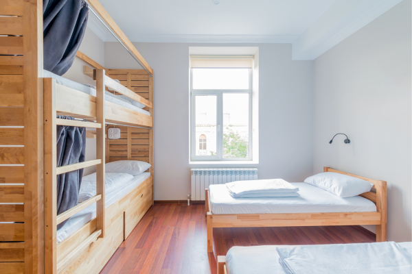 On-Campus vs Off-Campus: Best Housing for International Students 12 Bright dorm room with bunk beds and wooden furniture, showing on-campus housing for international students.