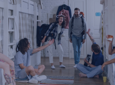 On-Campus vs Off-Campus: Best Housing for International Students 48 A group of happy travelers socialize in a cozy hostel dormitory, creating a welcoming backpacking atmosphere.