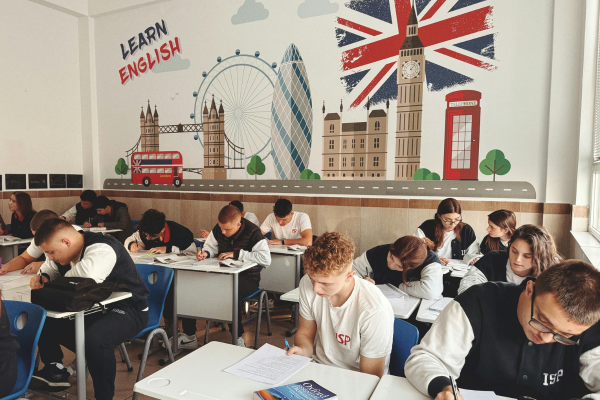 10 Essential Tips for New ESL Teachers: How to Teach English Like a Pro 9 Students learning English in a classroom with UK-themed murals of London landmarks and a Learn English sign.