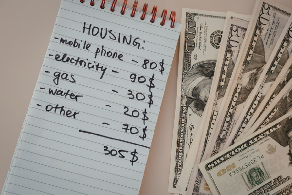 Financial Literacy: Managing Multi-Currencies and Budgeting Tips for International Students 5 Budget expenses list and US dollars, showing costs like mobile, electricity, and gas amounting to $305.