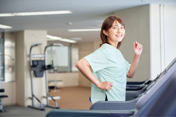 10 Strategies for Overcoming Culture Shock while Studying Abroad in 2026 8 Woman jogging on a treadmill in a gym, smiling and looking back.