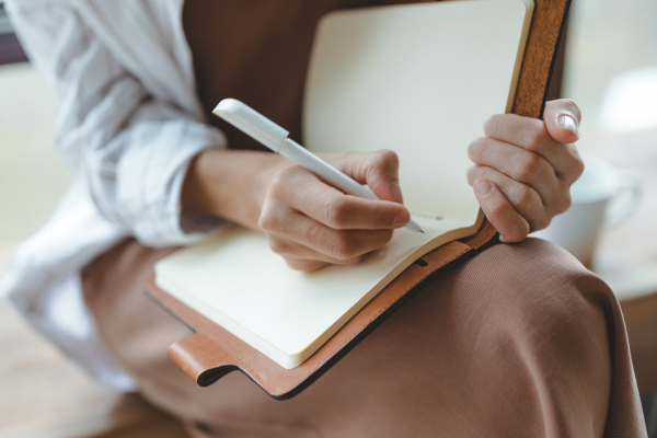 10 Strategies for Overcoming Culture Shock while Studying Abroad in 2026 9 Person writing in a notebook, capturing thoughts and ideas. Cozy setting, focus on creativity and journaling.
