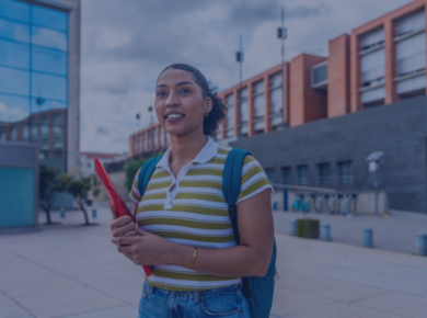 How Career-Focused Universities Help Reduce Student Debt and Improve Career Outcomes 50 Young woman with a backpack and notebook standing outside modern university building, smiling confidently.