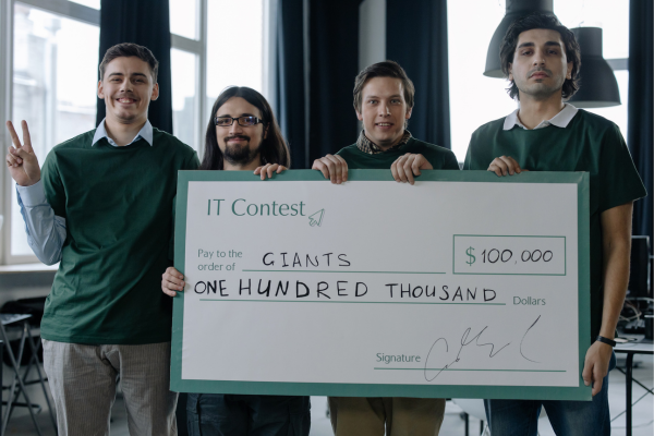 Why Donate to STEM Education? The Ripple Effect of Giving 11 Four men holding a $100,000 prize check at an IT contest, celebrating their achievement.
