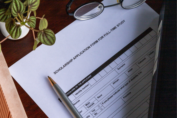 Why Donate to STEM Education? The Ripple Effect of Giving 10 Scholarship application form with pen and glasses on wooden desk, ready for completion.