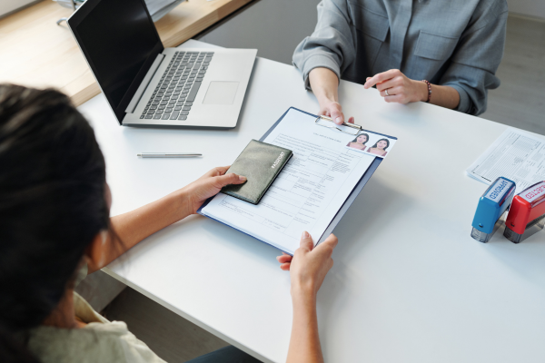 The New F-1 Visa Rules 2026: Simplified for International Students 4 Student submitting immigration documents during an appointment about new F-1 visa rules
