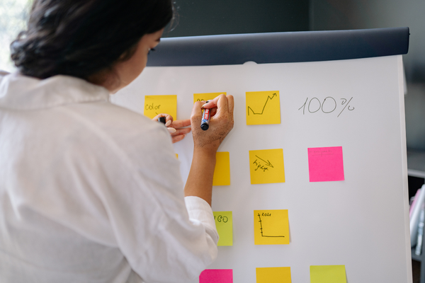 The Future of Business Development: How AI Is Changing the D.C. Market 6 Business development professional mapping out strategy on a whiteboard with growth metrics.