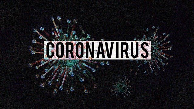 Coronavirus text over artistic virus representation on dark background, highlighting pandemic concept.