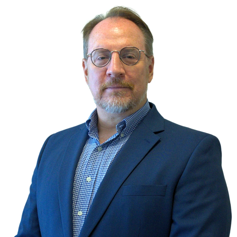 Business professional in a blue suit and glasses against a white background.