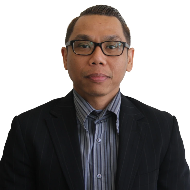 Pipop Nuangpookka wearing glasses, a striped shirt, and a dark blazer, posing against a white background.