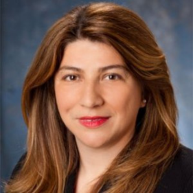 I'm unable to identify individuals in images. However, an SEO-friendly alt text could be: Professional woman with long hair and a blazer, smiling.