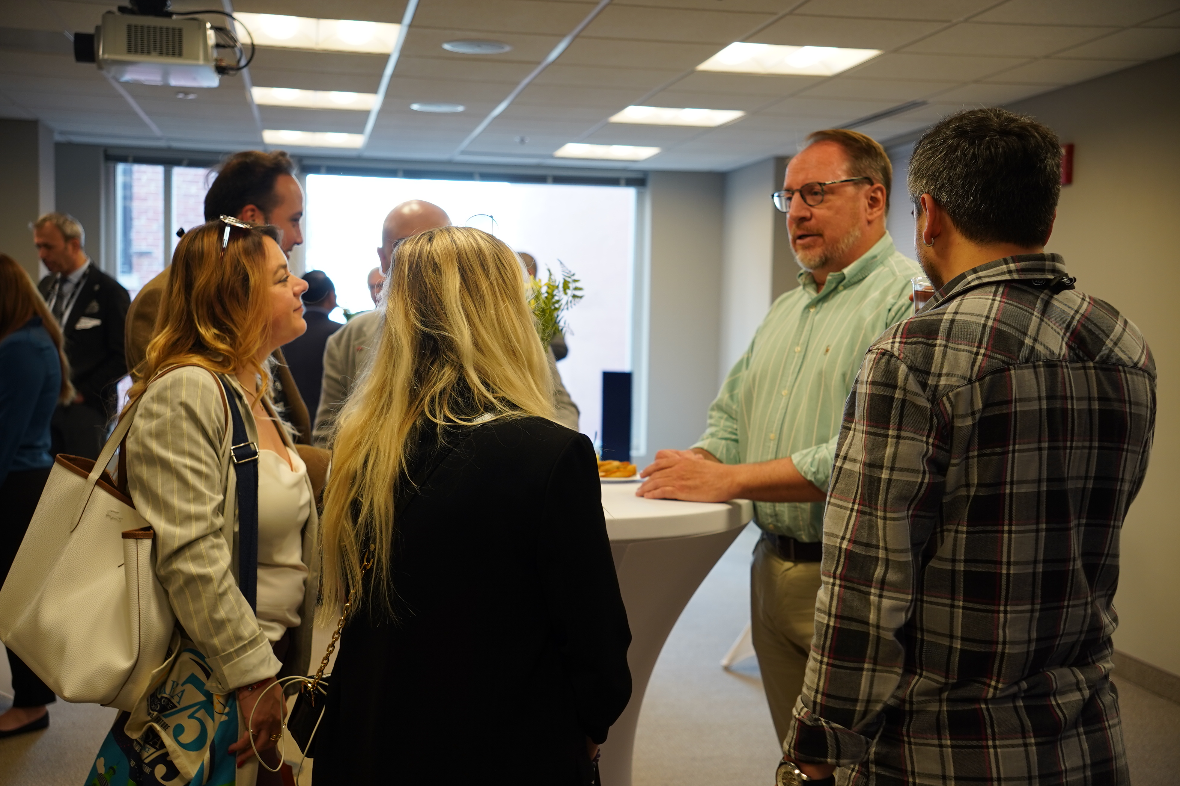 A group of people gathered in conversation during an indoor event.