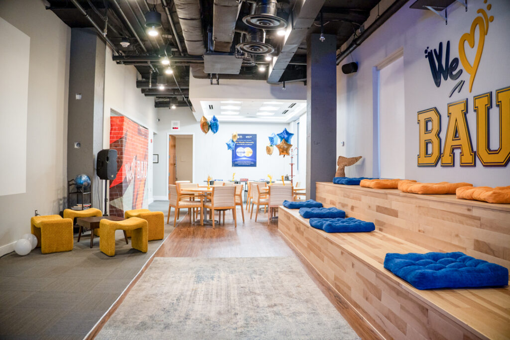 THE BAY Modern lounge with seating, colorful decor, and motivational wall graphics. Bright, inviting meeting space.