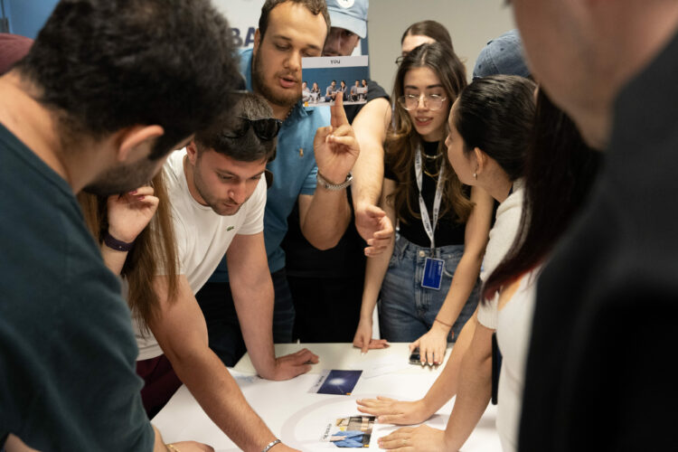 Group of people collaborating around a table, discussing creative ideas and teamwork.