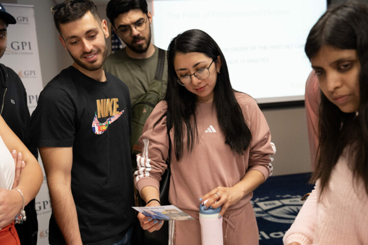 Group of young adults in discussion around a project, in a collaborative learning environment.
