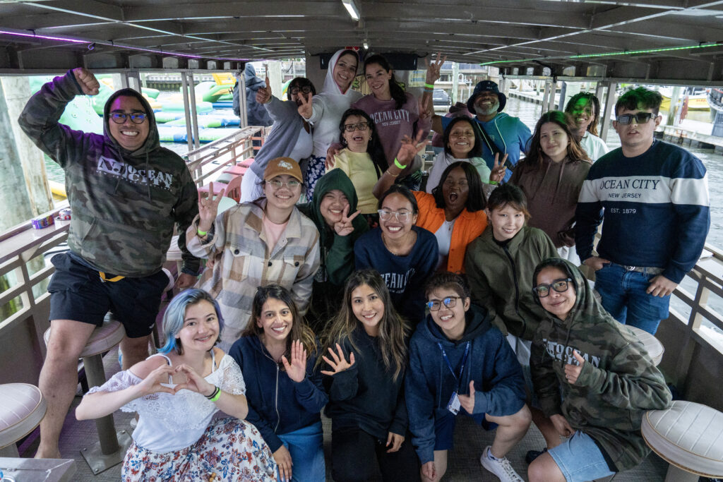360-DSC00809 A group of friends smiling and posing together on a boat, enjoying a joyful outing near the water.