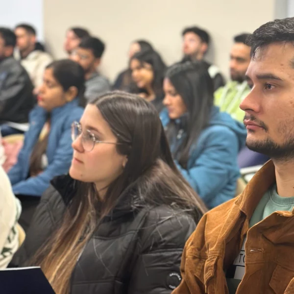 A focused group of students attentively listening in a classroom setting during a lecture or seminar.