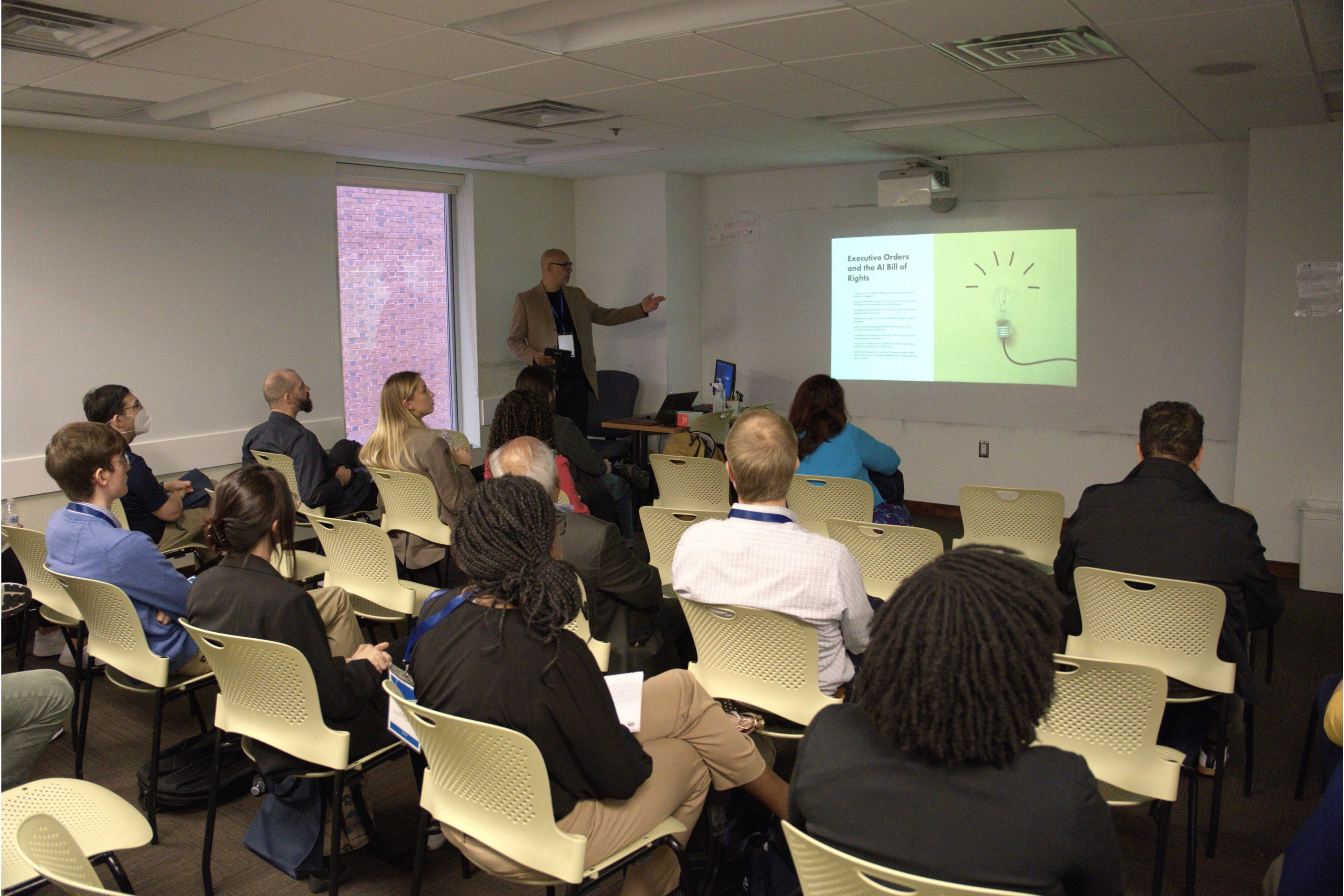 Person giving presentation on AI Bill of Rights to engaged audience in a lecture room.