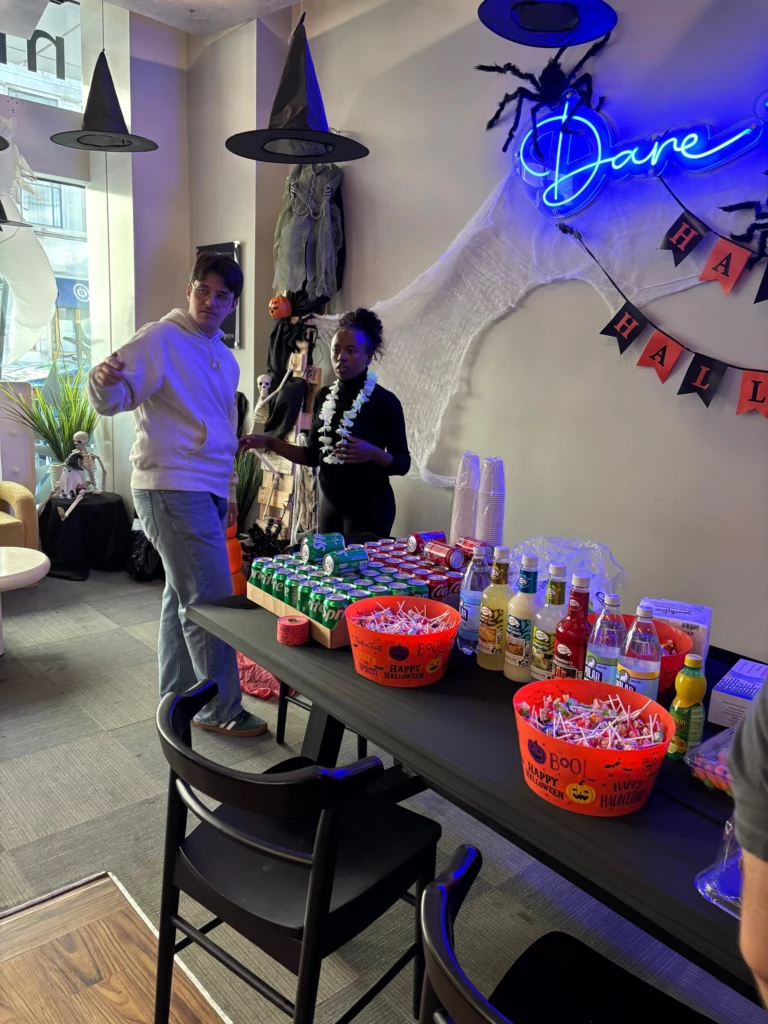 SGA Halloween Party 2025 Halloween-themed office gathering with decorations, snacks, and drinks on display.