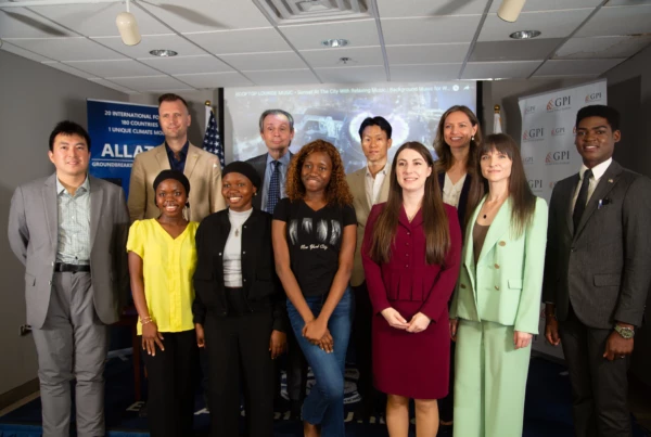 Diverse group of professionals gathered at a corporate event, smiling in a conference room setting.
