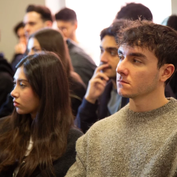 Audience attentively listens during a seminar, focused on the speaker's presentation in a classroom setting.