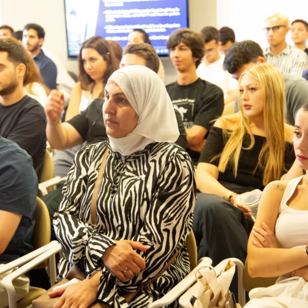 Diverse audience attentively listening at a seminar, showcasing engagement and focus in a modern learning environment.
