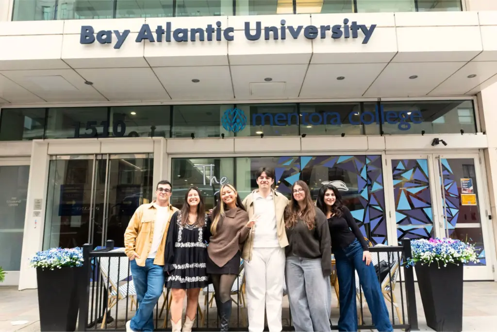 Group of smiling students in front of Bay Atlantic University building entrance, vibrant atmosphere.