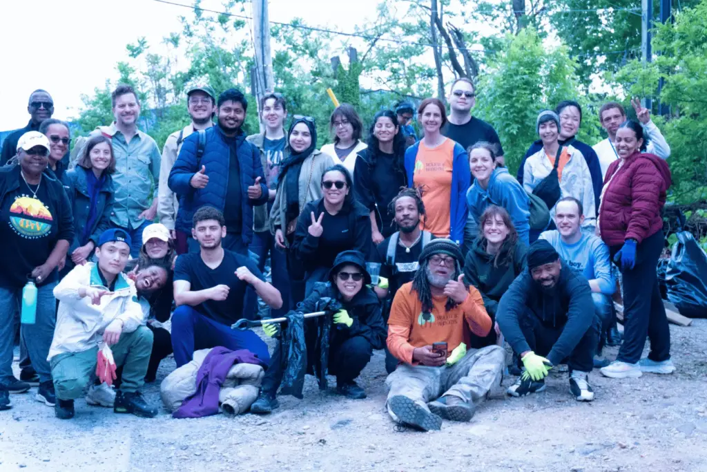 BAU Program Images (76) Group celebrating Earth Day cleanup with Anacostia Watershed Society sign, smiling outdoors.