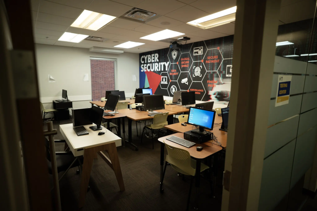 DSC02388 Cybersecurity training room with computers and digital security-themed wall graphics.