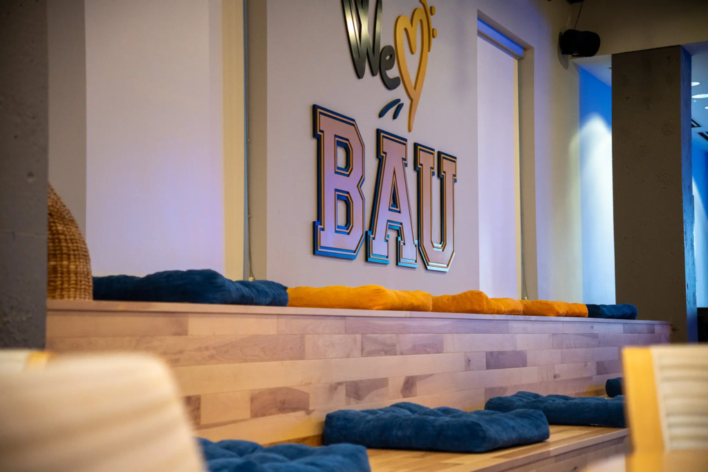 DSC06466 Cozy seating area with cushions beneath We ♥️ BAU sign on a wooden staircase.