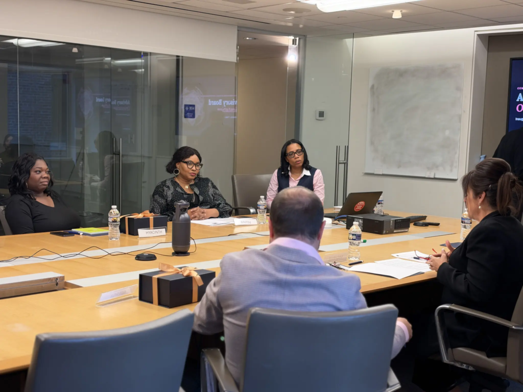 Team meeting in a modern conference room, discussing business strategies around a large table.